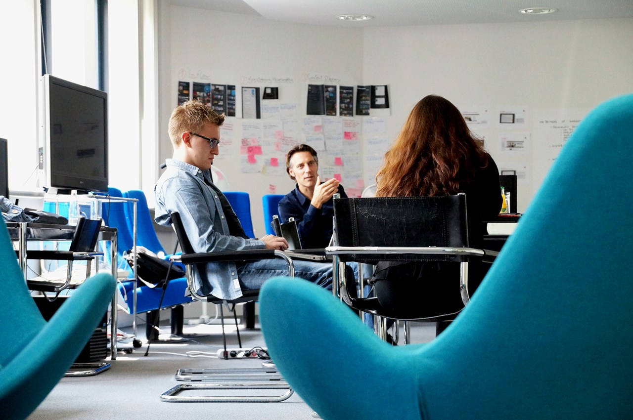Pessoas conversam na mesa sentadas em um escritório descolado de uma startup