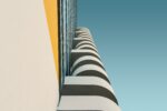 Low angle shot of a white concrete building under the clear blue sky